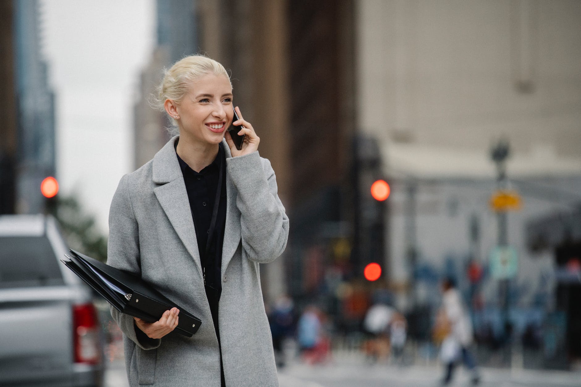 cheerful businesswoman talking on smartphone in town