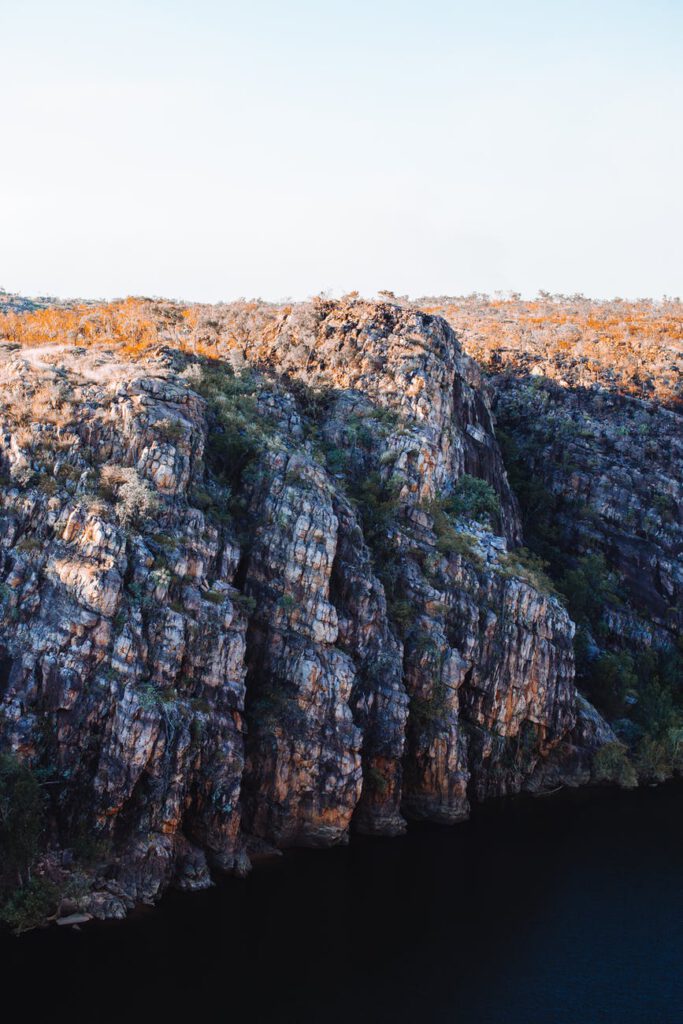 rocky cliff near calm river in peaceful nature